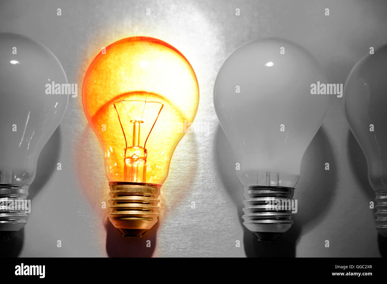 One bright bulb in line of dull light bulbs. Standing out concept Stock  Photo - Alamy