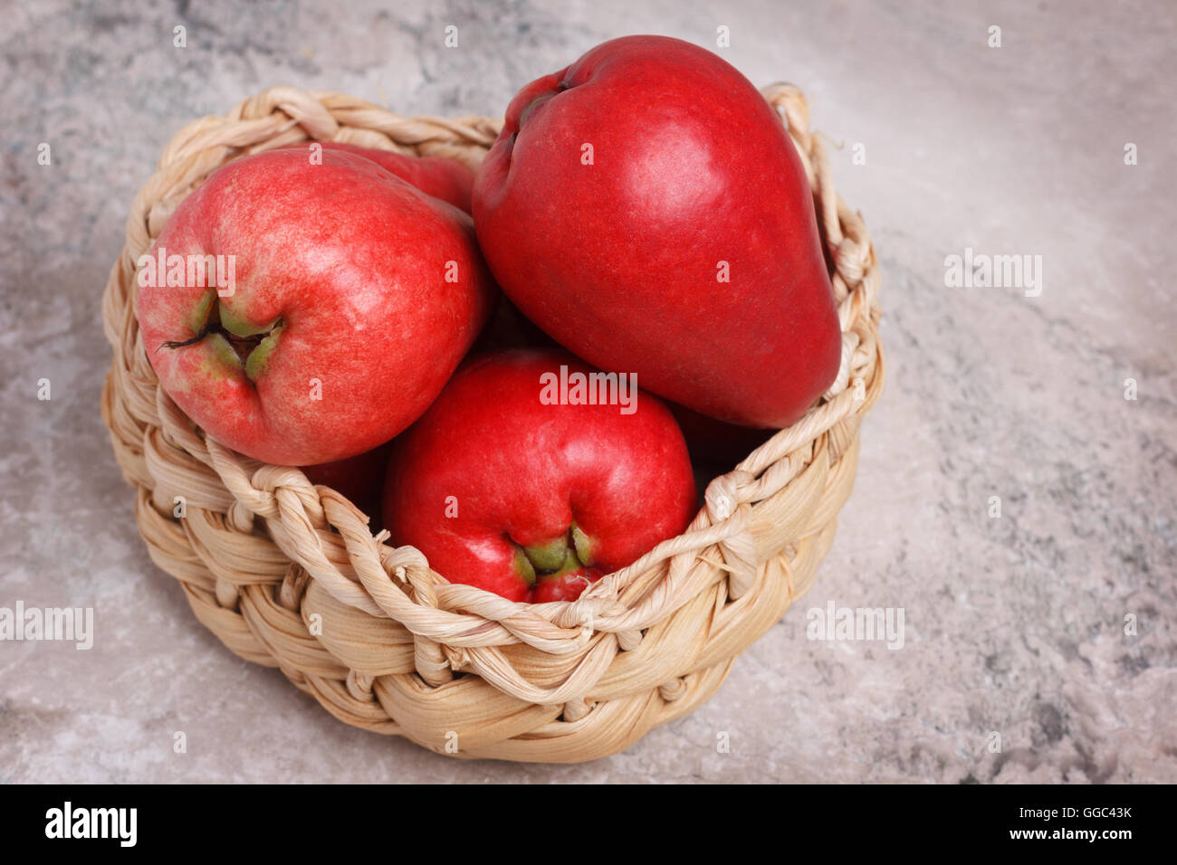 Tropical fruit Acmella oleracea (toothache plant, paracress, electric daisy, jambu) in wicker basket on marble table Stock Photo