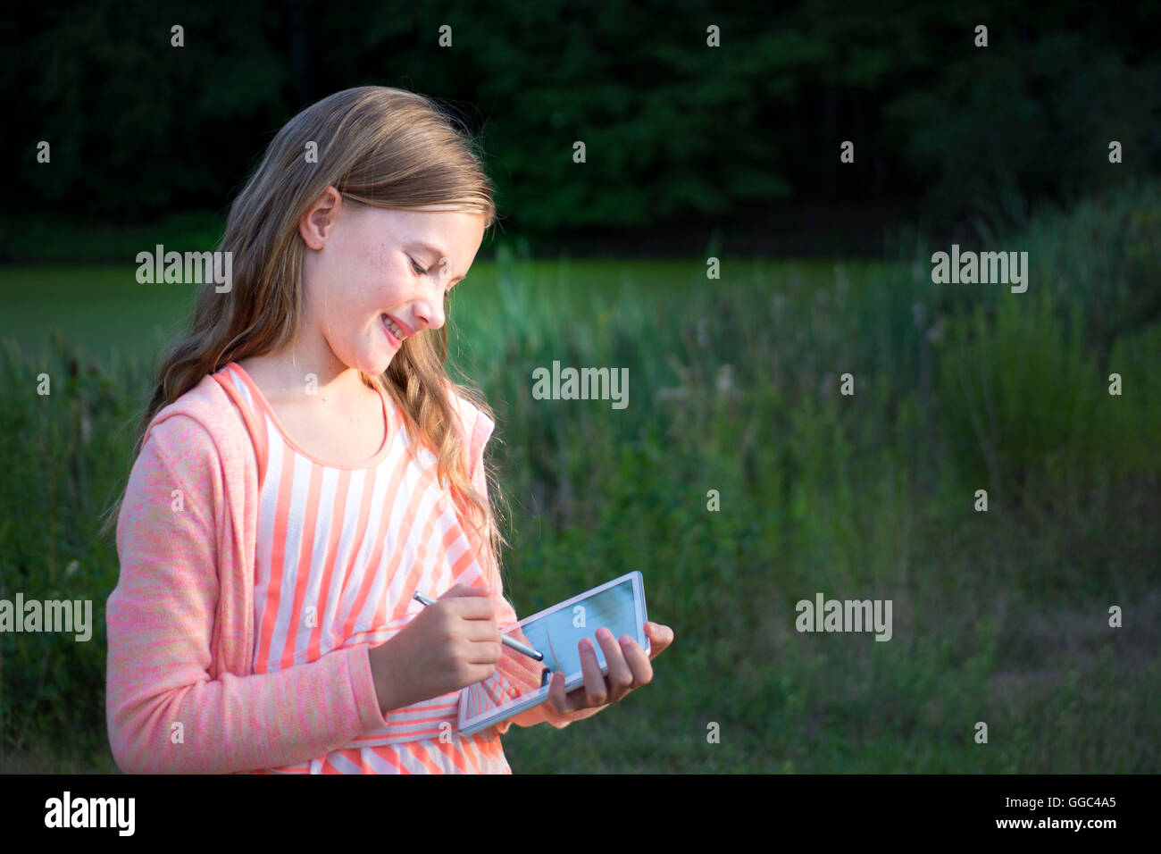 Girl with tablet drawing and smiling Stock Photo Alamy
