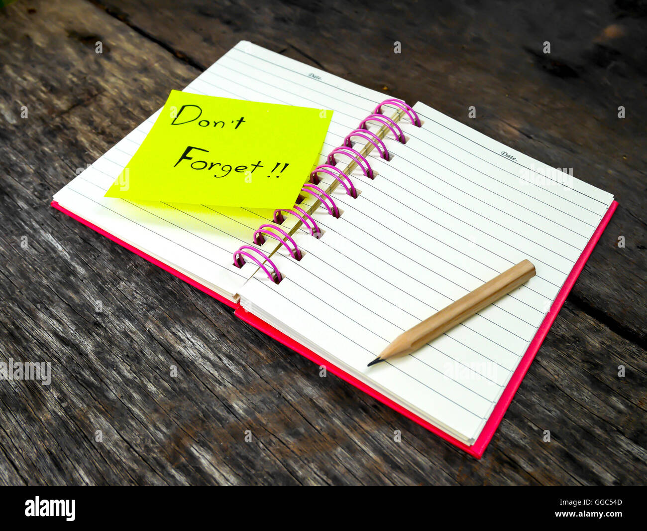 Reminder paper note in note book on wooden table with selective focus Stock Photo