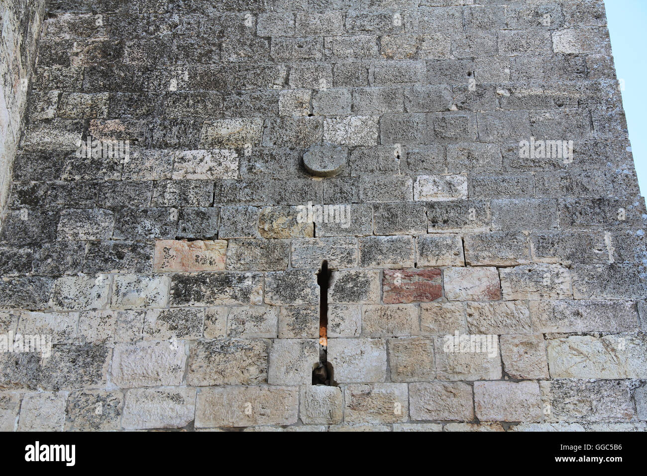 A medieval castle arrow slit in the historic wall of Old Jerusalem, Israel. Stock Photo