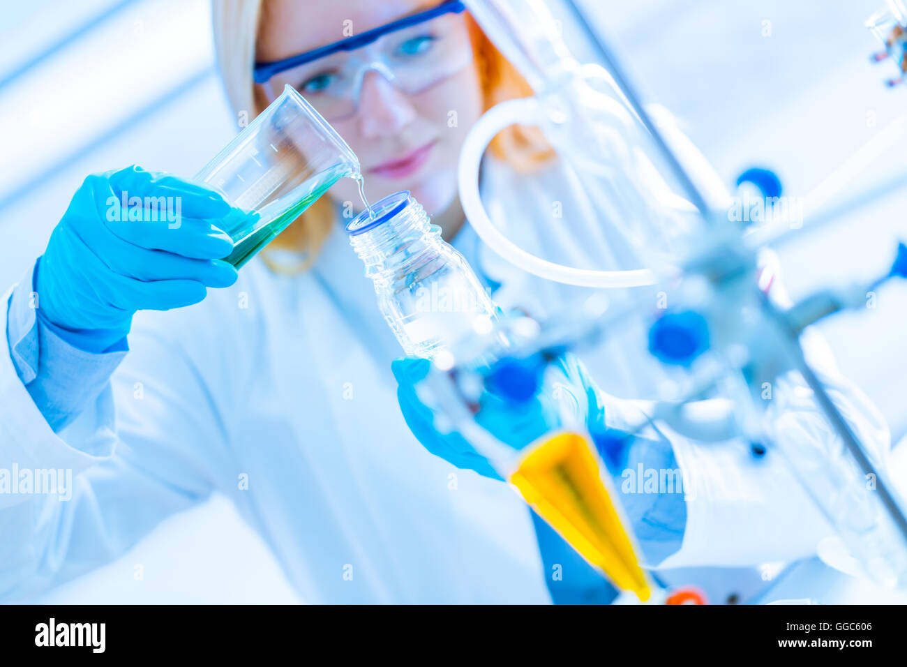 Chemical laboratory scene: attractive young student scientist observing the blue indicator color shift after the solution Stock Photo