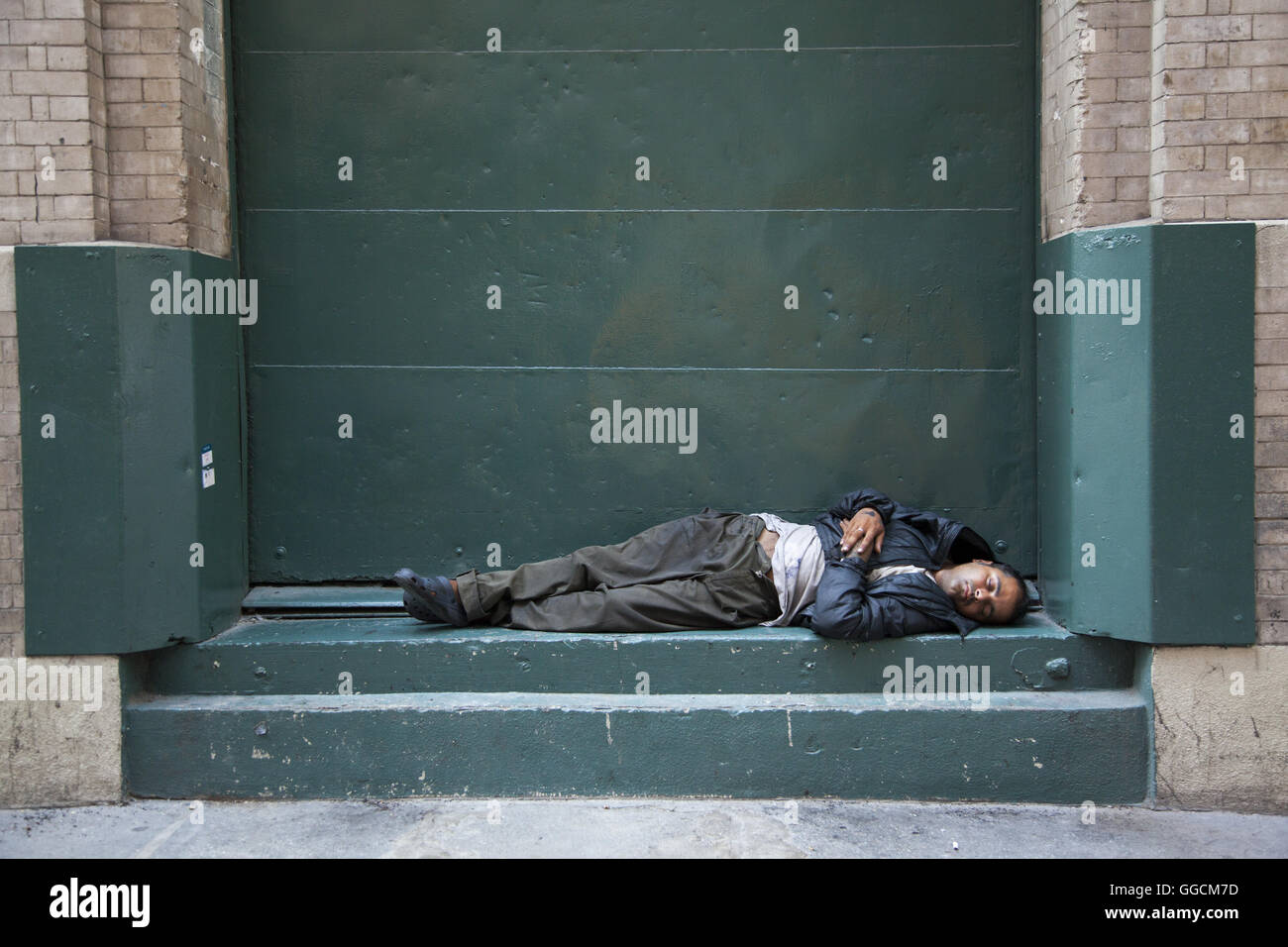 Man sleeps on a street loading dock in mistown Manhattan, New York City. Stock Photo