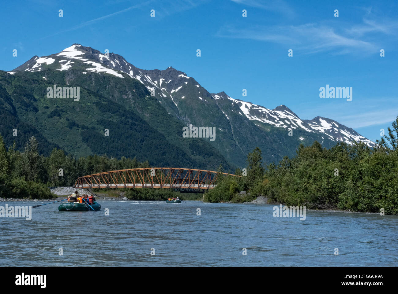 Several rafts are floating under a bridge on the Placer River in South Central Alaska. Stock Photo