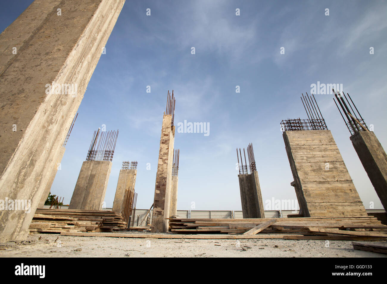 Construction site - Pillars of a building in the making against blue sky Stock Photo