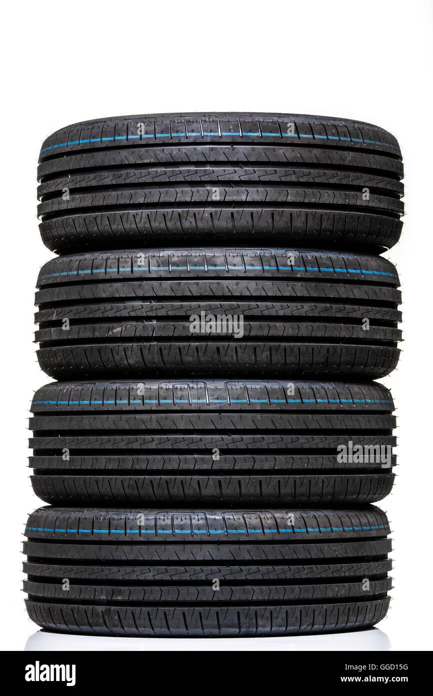 Stack of brand new high performance car tires on clean highkey white