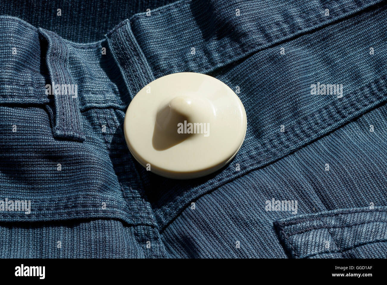 A shop security tag on a pair of trousers Stock Photo