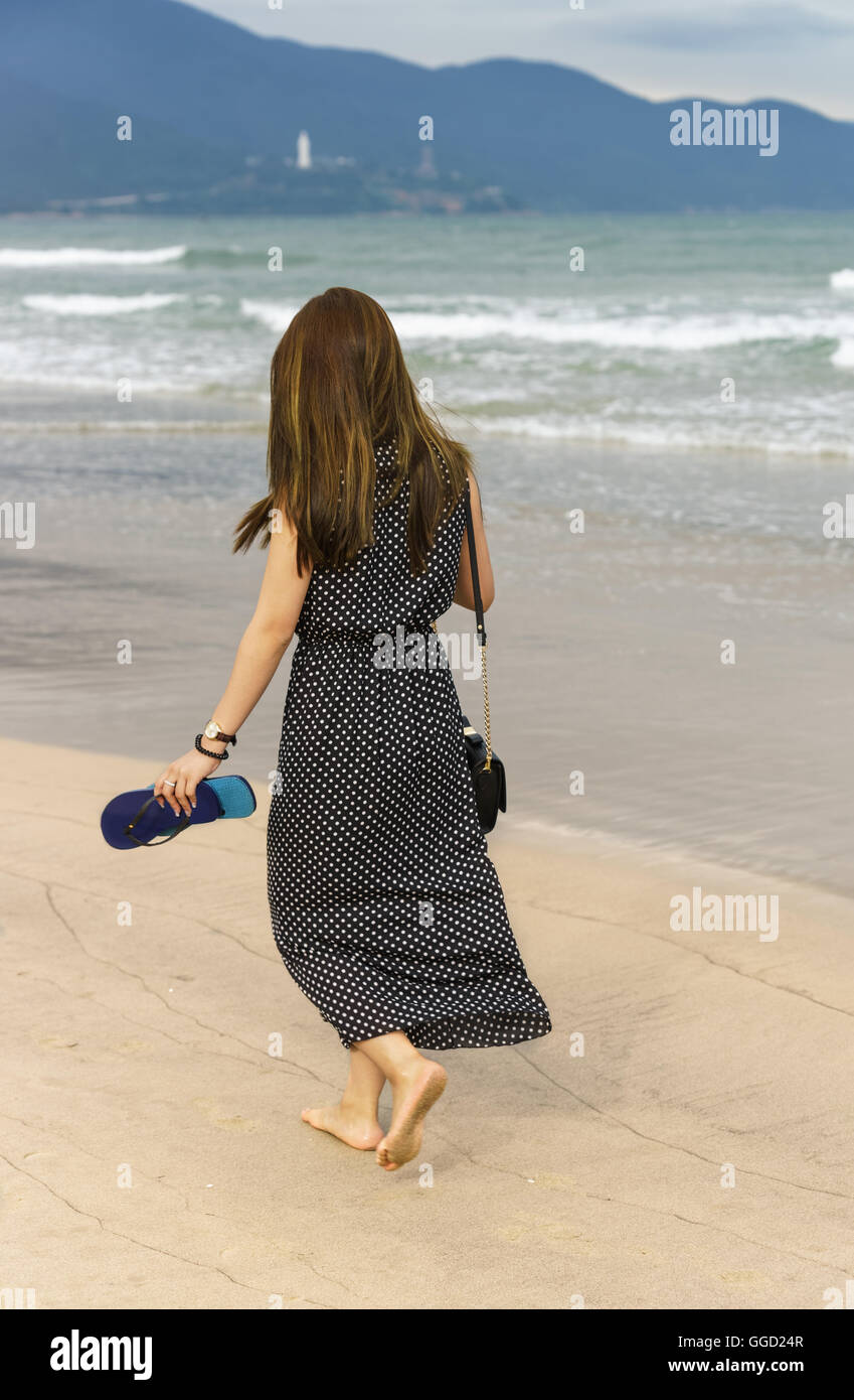 Young girl passing by on the China Beach in Danang, in Vietnam. No face  Stock Photo - Alamy