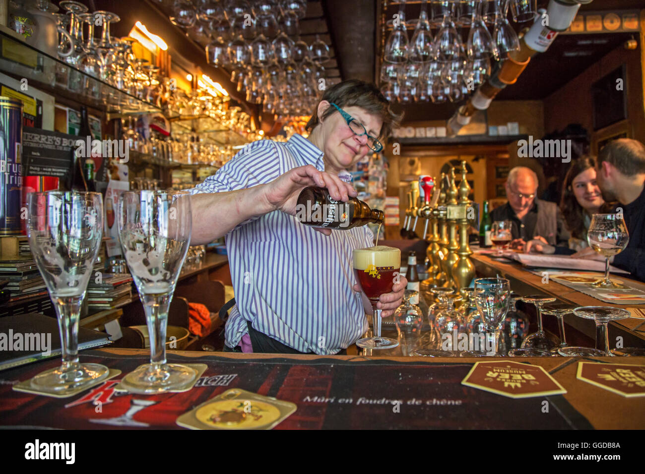 Bartender pouring Belgian beer in glass in the café 't Brugs Beertje in Bruges / Brugge, West Flanders, Belgium Stock Photo