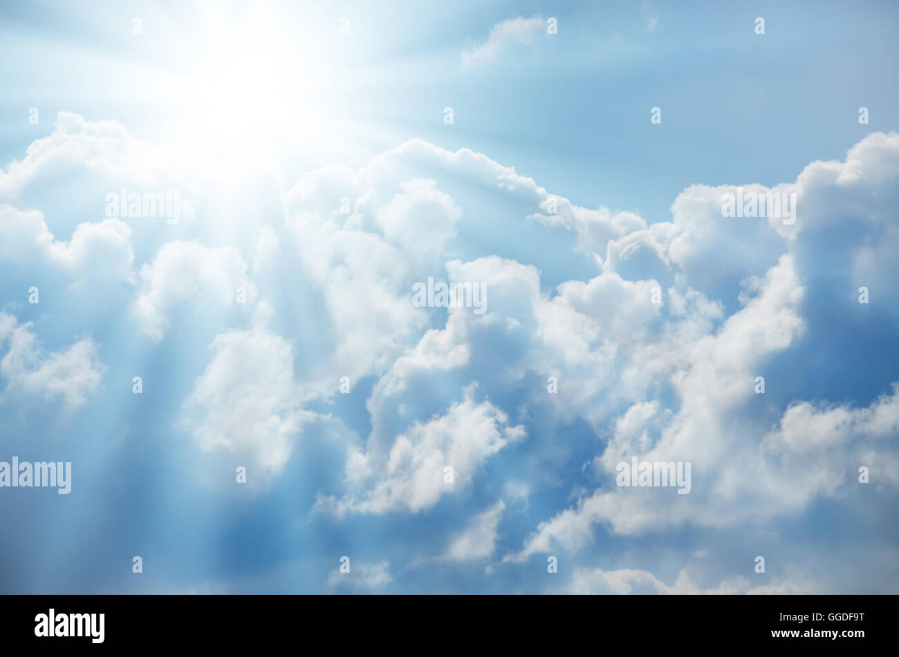 Bright sun shines among the white clouds Stock Photo