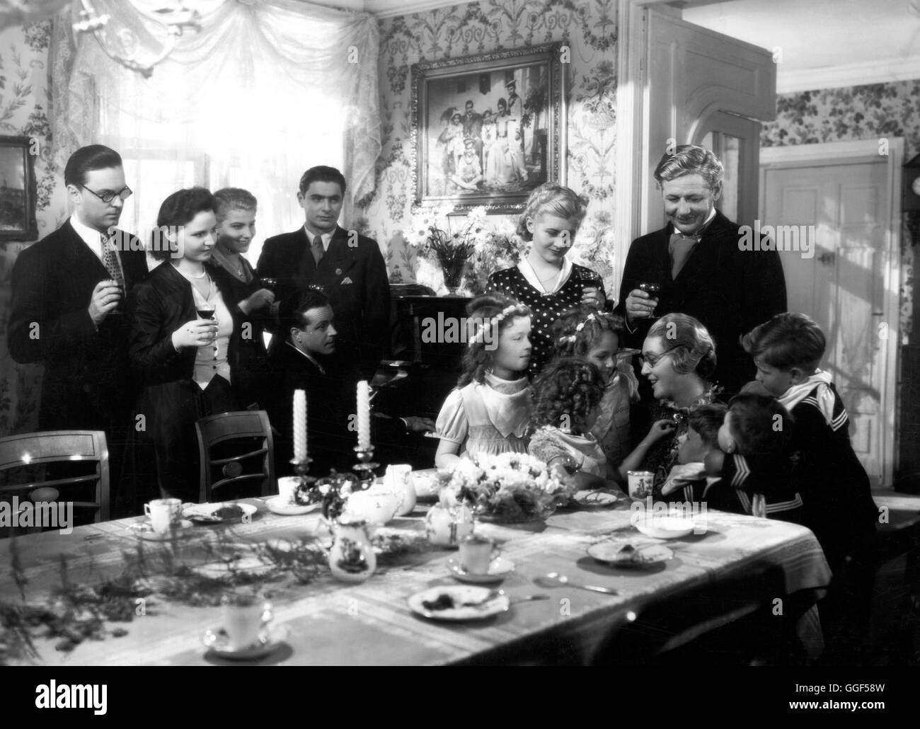 MUTTERLIEBE / Deutschland 1939 / Gustav Ucicky HANS HOLT, OLLY HOLZMANN, WINNIE MARKUS, WOLF ALBACH-RETTY (am Klavier), RUDOLF PRACK, SUSI NICOLETTI, PAUL HÖRBIGER, KÄTHE DORSCH (Großmutter mit Enkelkindern) in 'Mutterliebe', 1939. Regie: Gustav Ucicky Stock Photo