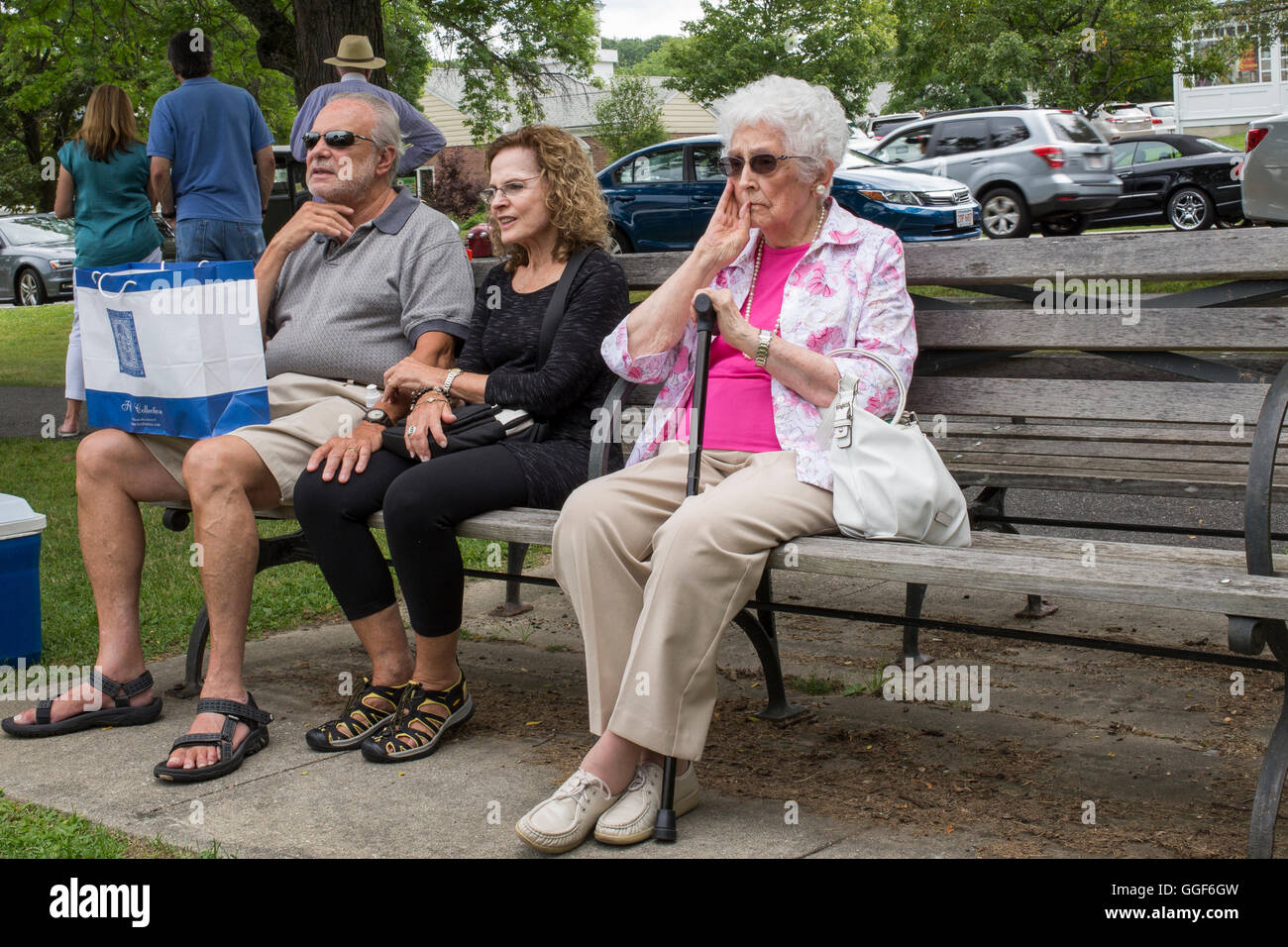 People sitting on a bench at an Art and Craft Show in Lenox, MA Stock Photo