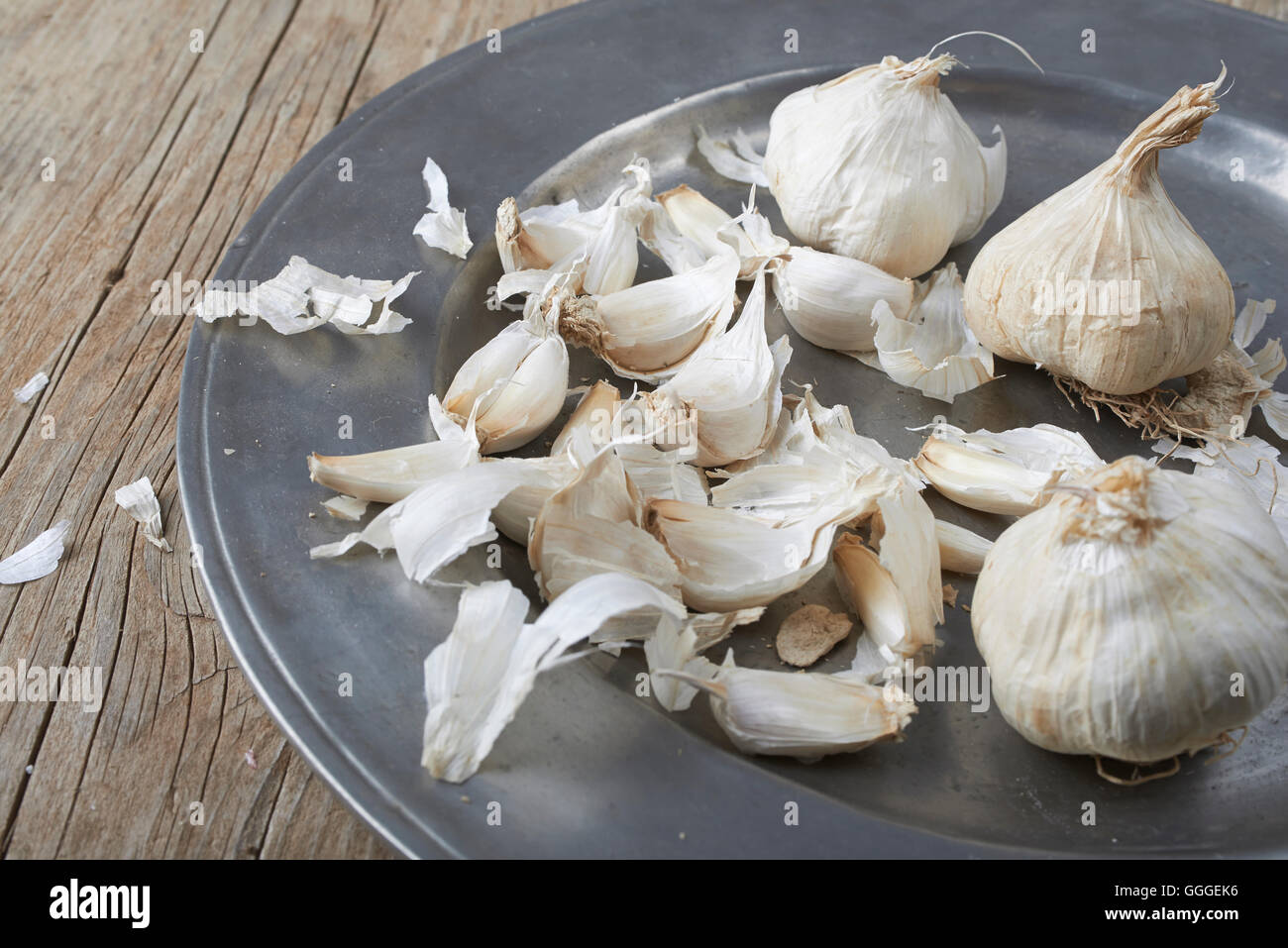 whole and cloves of organic garlic in plate on a wooden table Stock ...