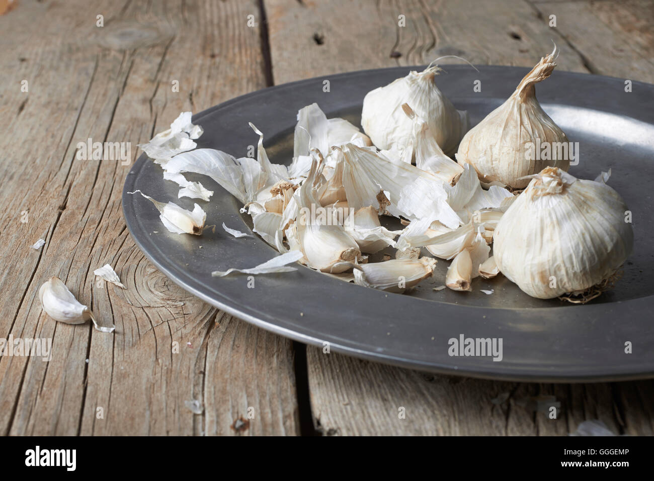 whole and cloves of organic garlic in plate on a wooden table Stock ...