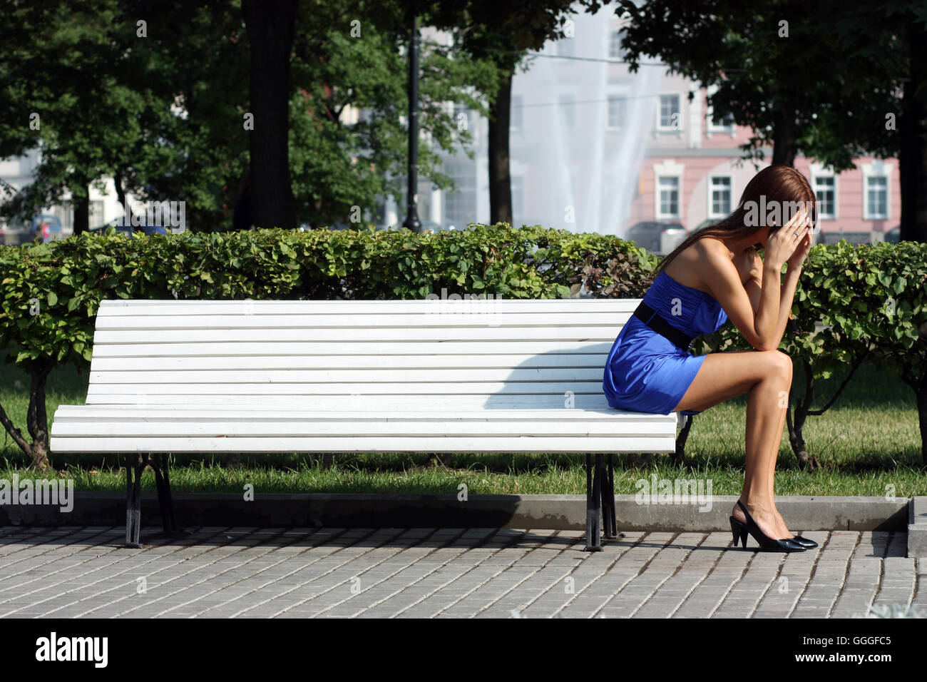 young woman sitting on a park bench Stock Photo - Alamy