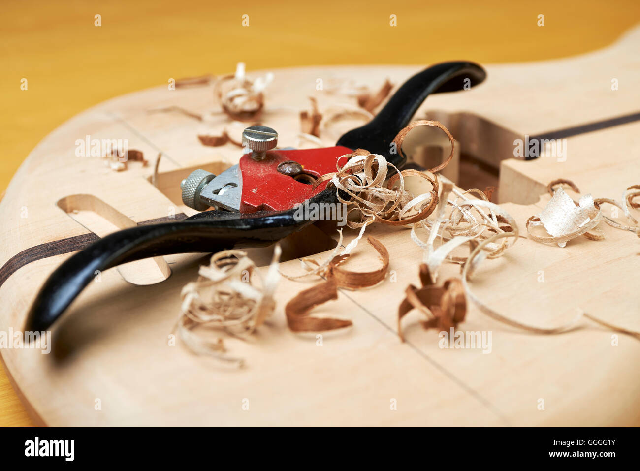 Bass guitar under construction, with tools and accessories Stock Photo