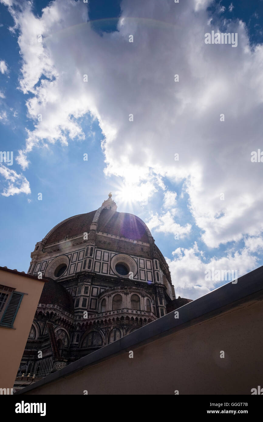 Sun flare through clouds above Il Duomo, dome of the cathedral de Santa Maria del Fiore, Florence, Tuscany, Italy Stock Photo