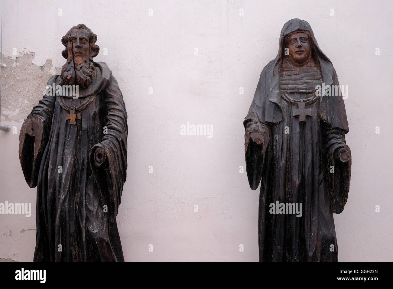 Old wooden figures at the courtyard of St Michael's Church or St. Michael the Archangel Church a former Roman Catholic church now the Church Heritage Museum in the Old Town of Vilnius in Lithuania Stock Photo