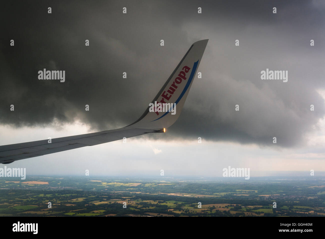 Air Europa wing flying under dark cloud Stock Photo