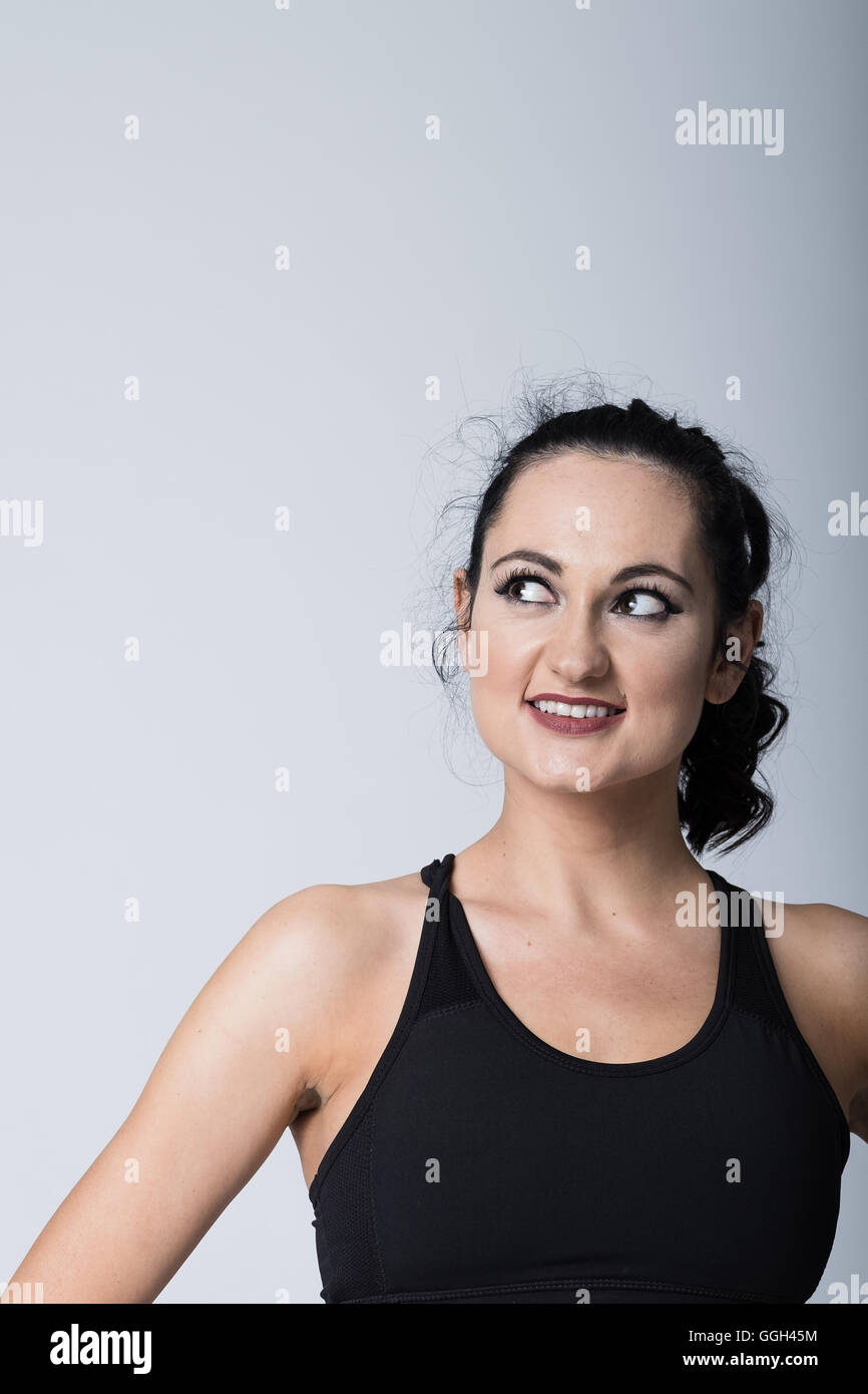 Woman in her 20s in fitness gear working out and exercising. Stock Photo