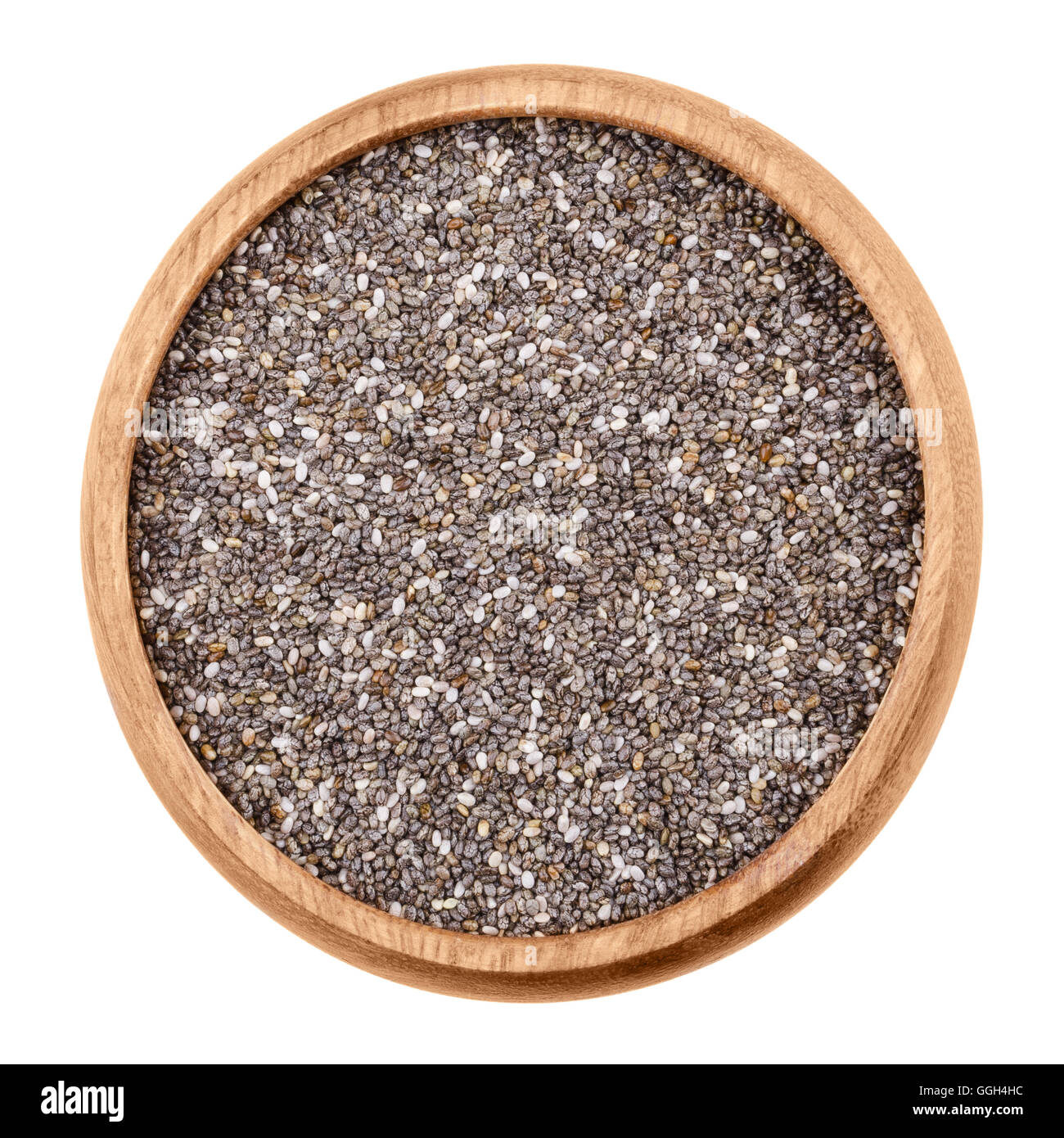 Chia seeds in a bowl on white background. Raw edible fruits of Salvia hispanica of the mint family, Lamiaceae, in a wooden bowl. Stock Photo
