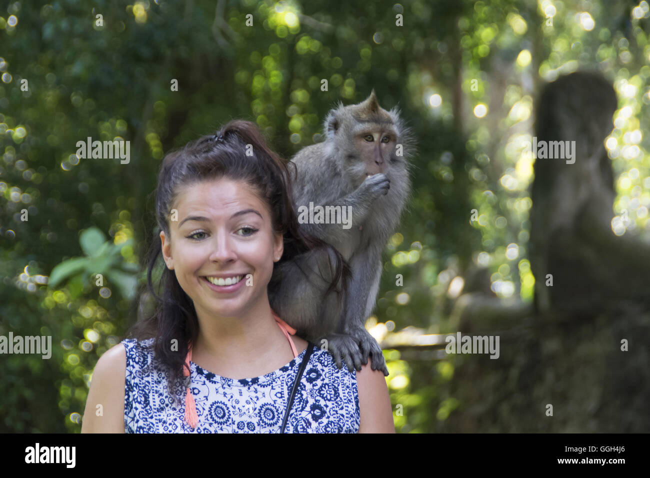 The crabeating macaque on a shoulder of a girl, Indonesia. Crabeating