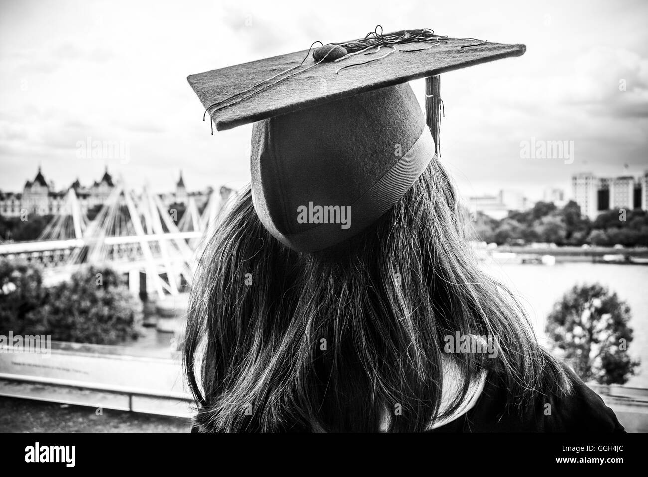 A young graduate wearing a mortarboard look towards future horizons Stock Photo