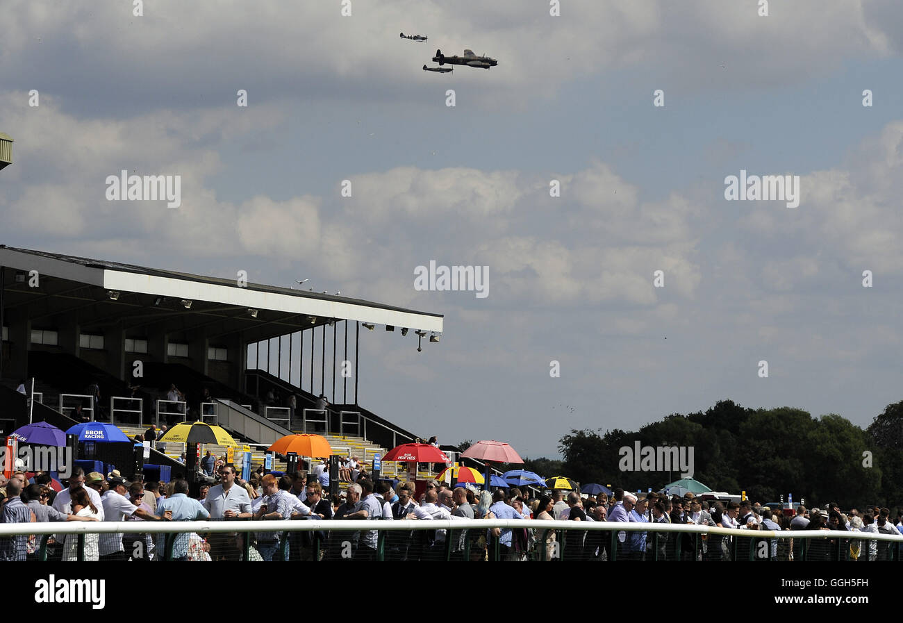 A Lancaster Bomber, Spitfire and Hurricane fly past Haydock Park on their way to the Blackpool Air Show during Betfred Rose Of Lancaster Stakes Ladies Day at Haydock Park Racecourse. Stock Photo