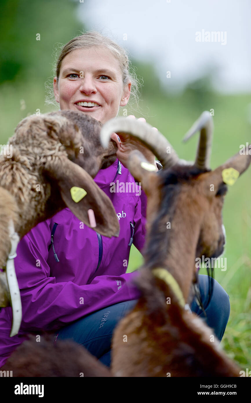 Woman sitting near a sheep and a goat, Chiemgau, Bavaria, Germany Stock Photo