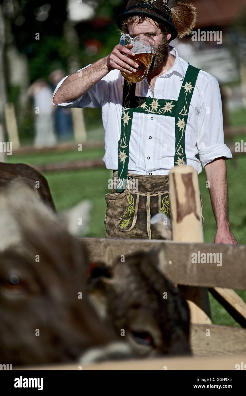 Man wearing traditional clothes drinking a glass of beer, Viehscheid