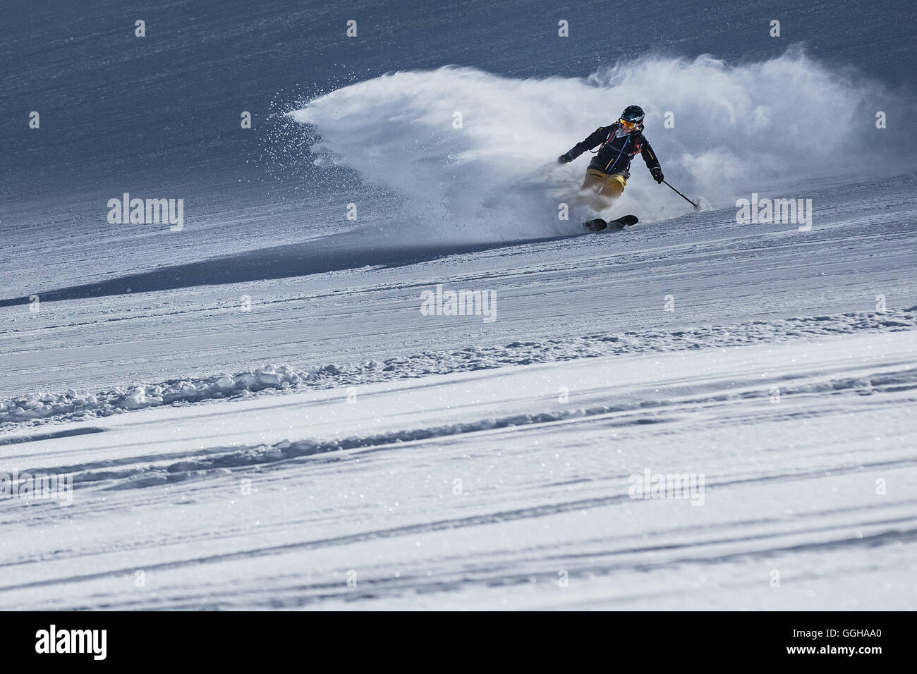 Young female freeskier riding through deep powder snow in the mountains, Pitztal, Tyrol, Austria Stock Photo