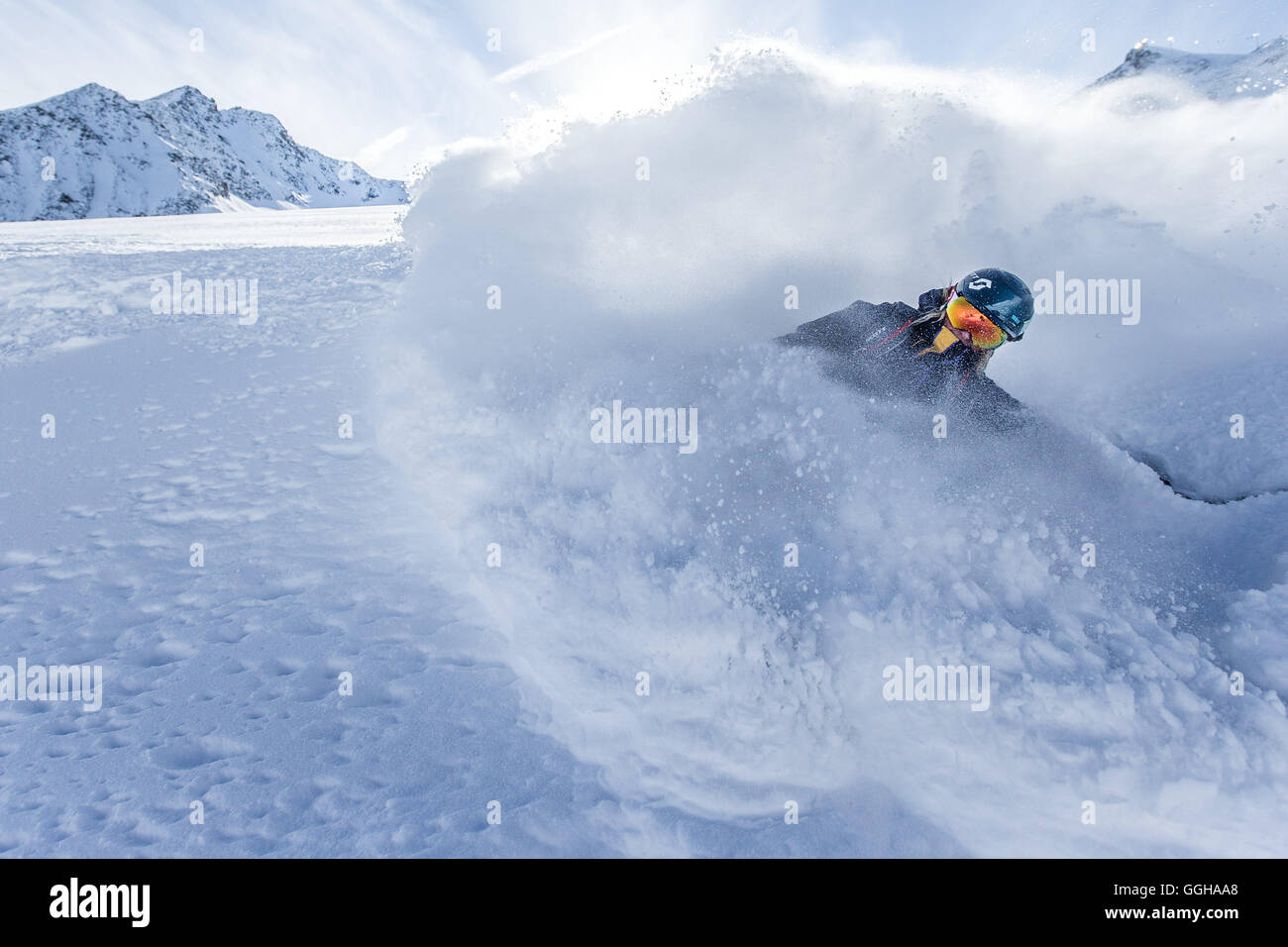 Young female freeskier riding through deep powder snow in the mountains, Pitztal, Tyrol, Austria Stock Photo