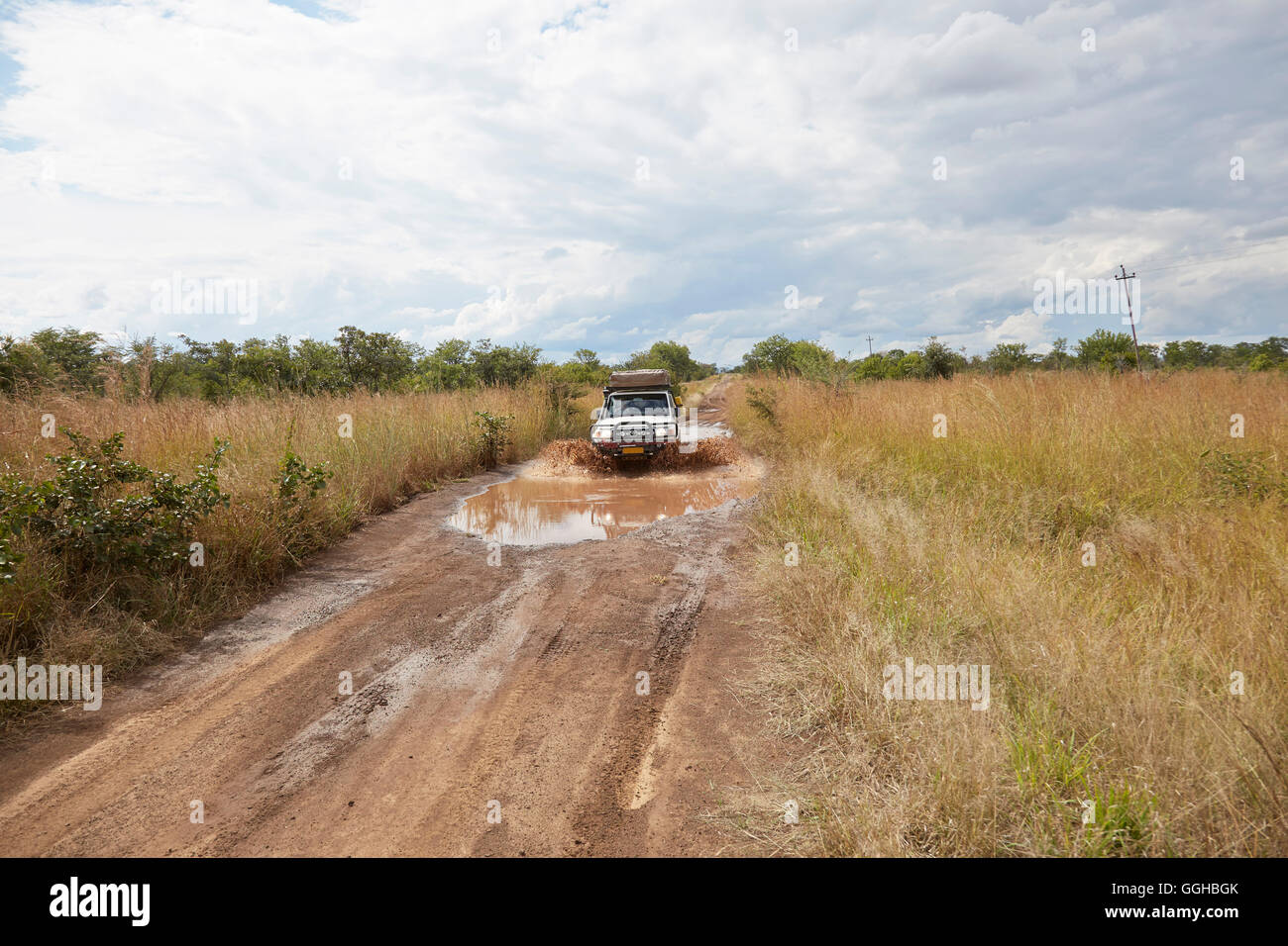 Off-road vehicle passing a mudhole, Kazuma Pan National Park, Livingstone, Zimbabwe Stock Photo