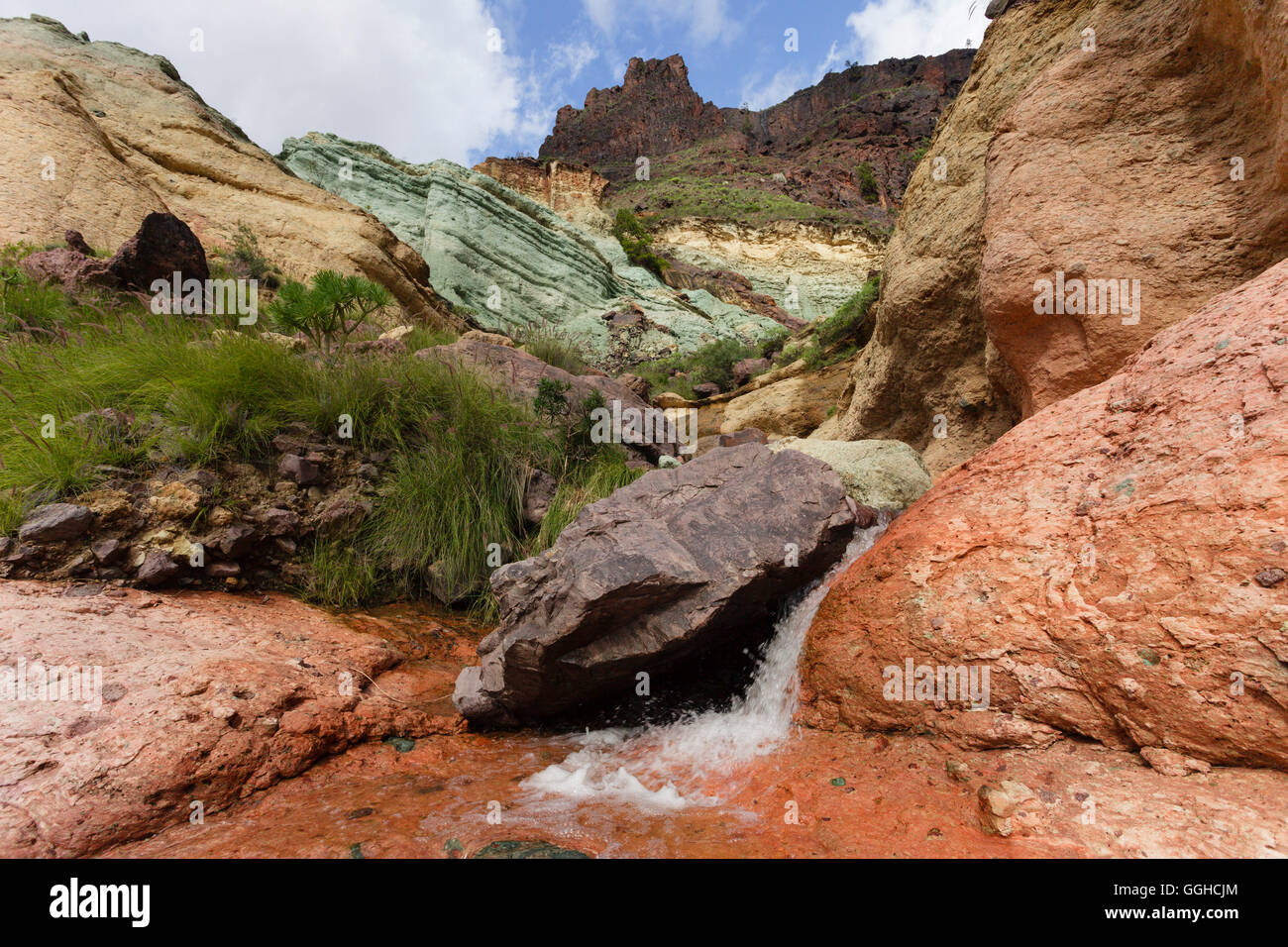 Los Azulejos, coloured volcanic rocks, creek, waterfall, near Mogan, Barranco de Veneguera, Parque Rural del Nublo, Natural Pres Stock Photo
