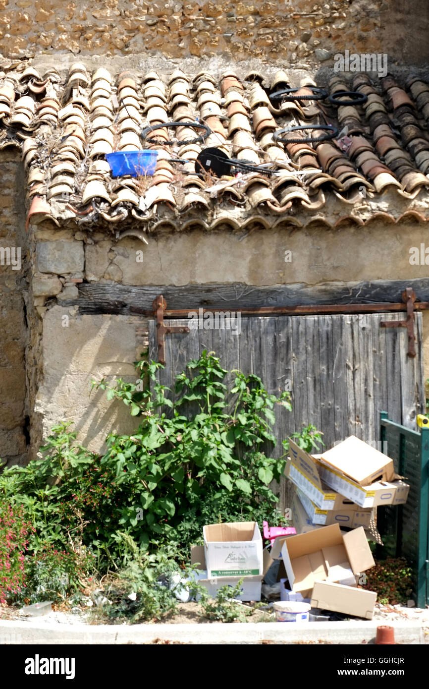 Refuse or rubbish left next to an old building that looks unused for a period of time in the suburbs of Narbonne in southwest Fr Stock Photo