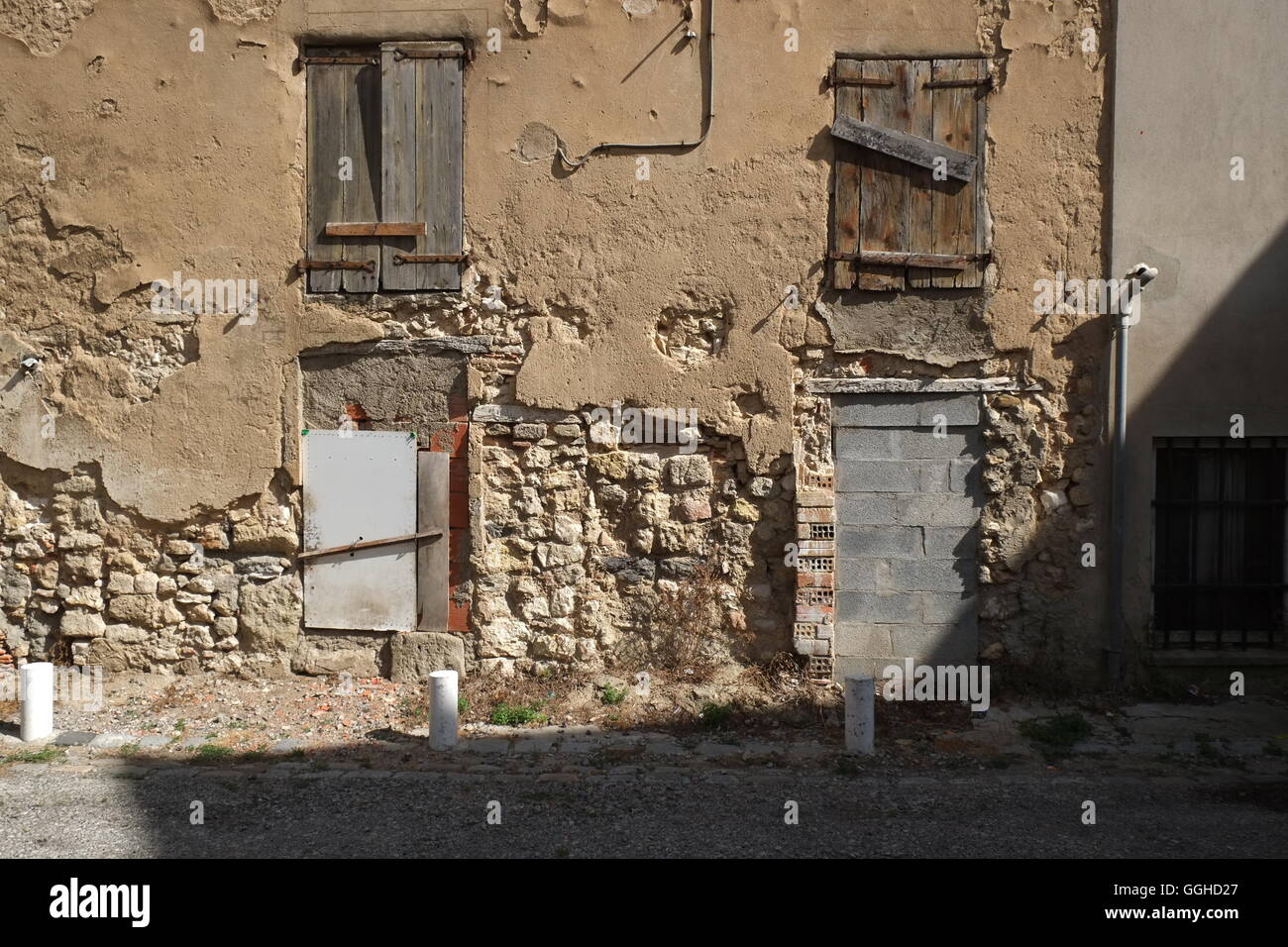 old character french architecture including four windows that have been roughly repaired in a practical rather than attractive s Stock Photo