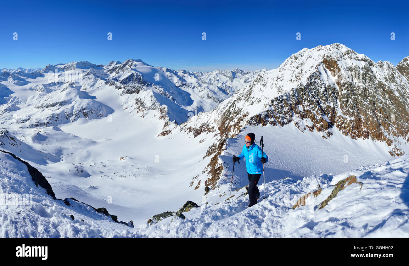 Femal back-country skier ascending to Agglsspitze, mountain scenery in background, Pflersch valley, Stubai Alps, South Tyrol, It Stock Photo