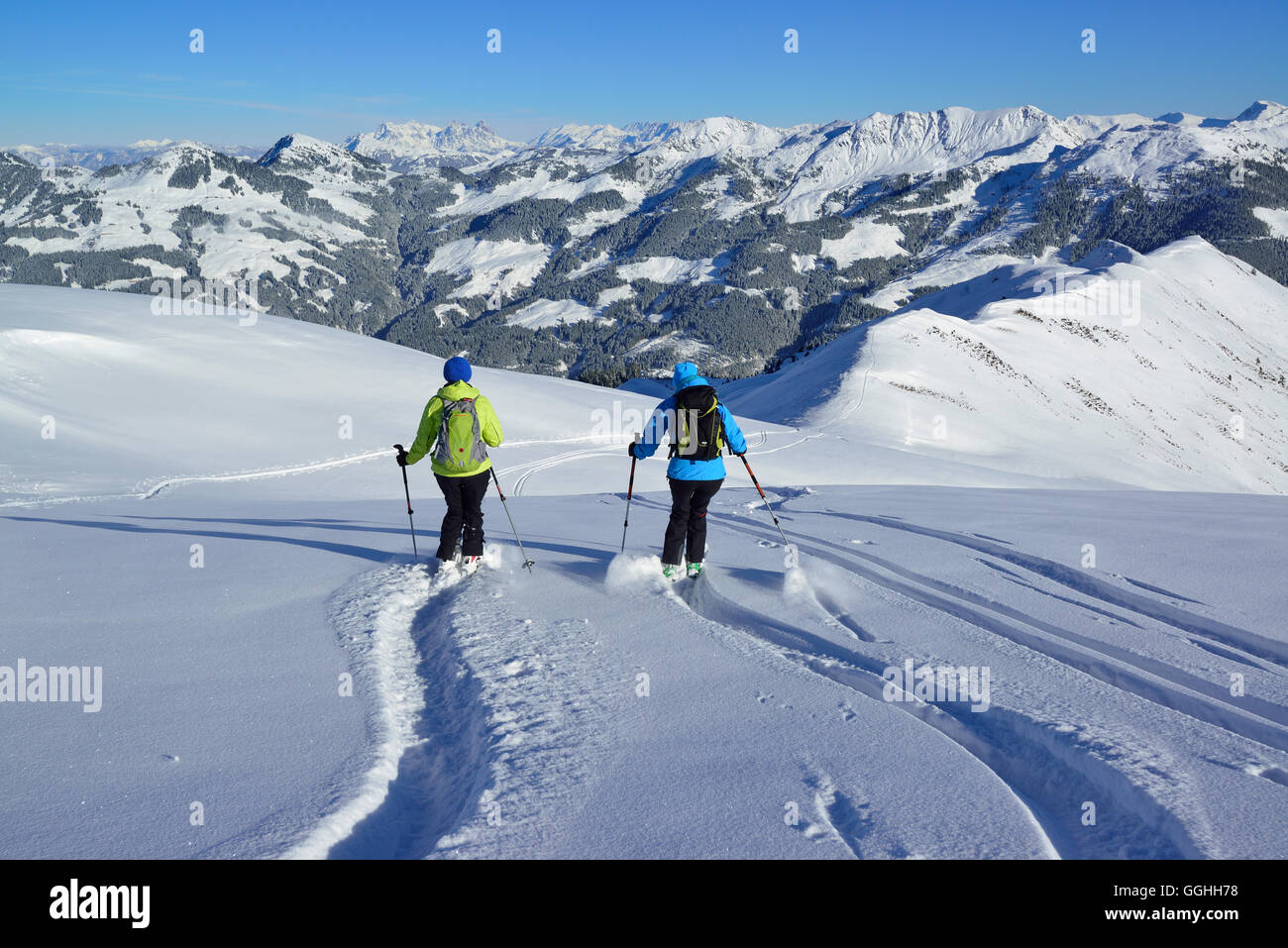 Two female back-country skiers downhill skiing from mount Steinberg, Kitzbuehel Alps, Tyrol, Austria Stock Photo