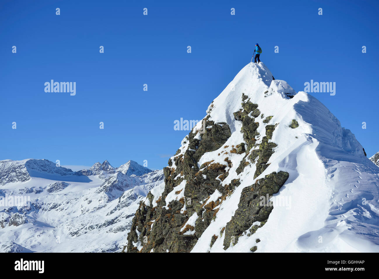 Female back-country skier standing on summit of Aeusseres Hocheck, Pflersch valley, Stubai Alps, South Tyrol, Italy Stock Photo