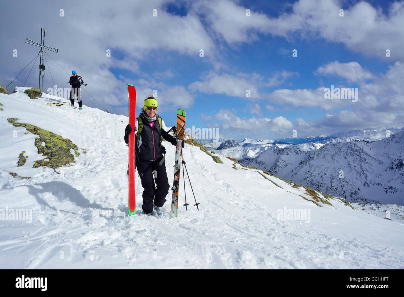 Two back-country skiers beside summit cross, Schafsiedel, Kitzbuehel Alps, Tyrol, Austria Stock Photo