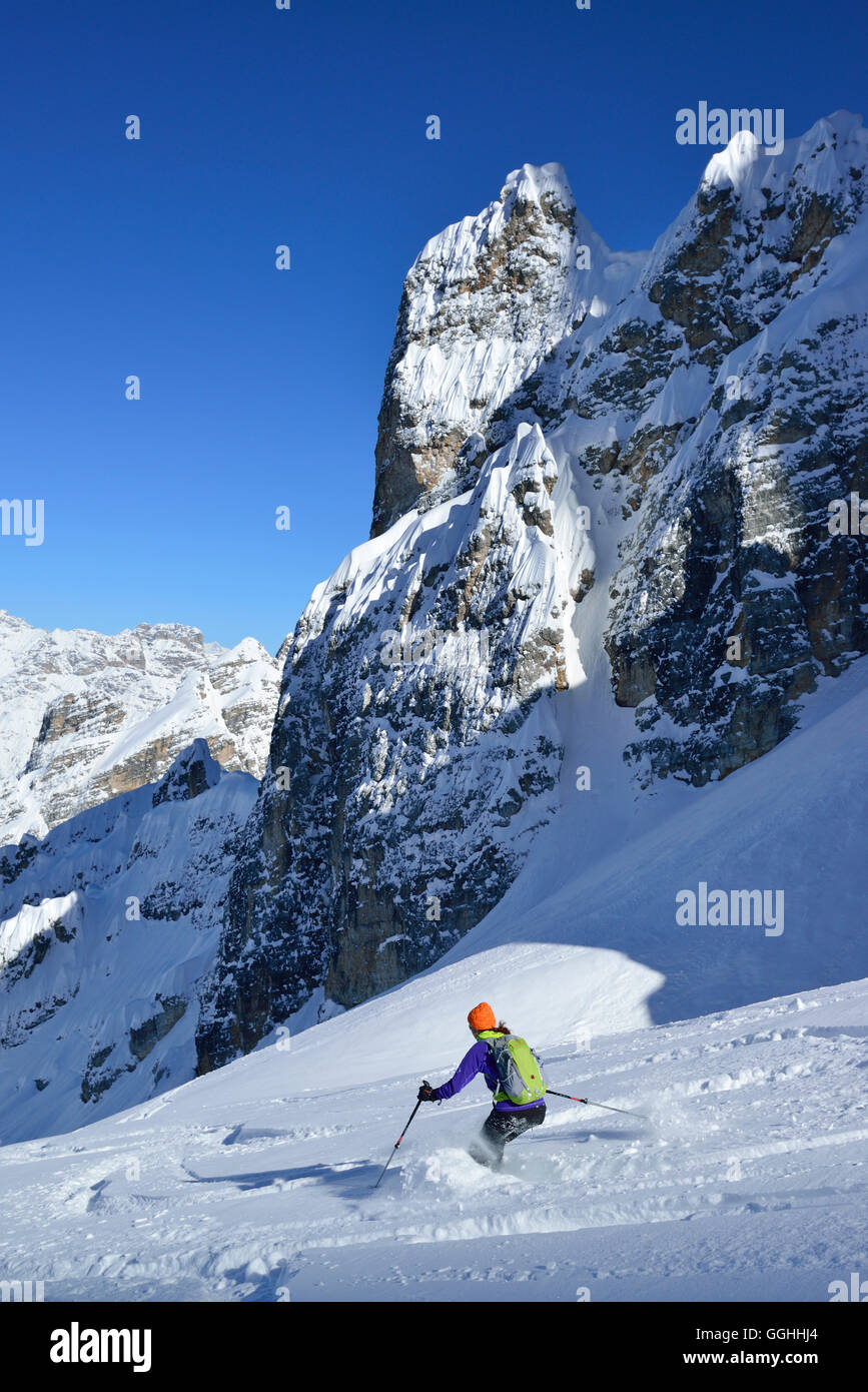 Female back-country skier downhill skiing from Cristallo wind gap, Cristallo, Dolomites, Belluno, Veneto, Italy Stock Photo