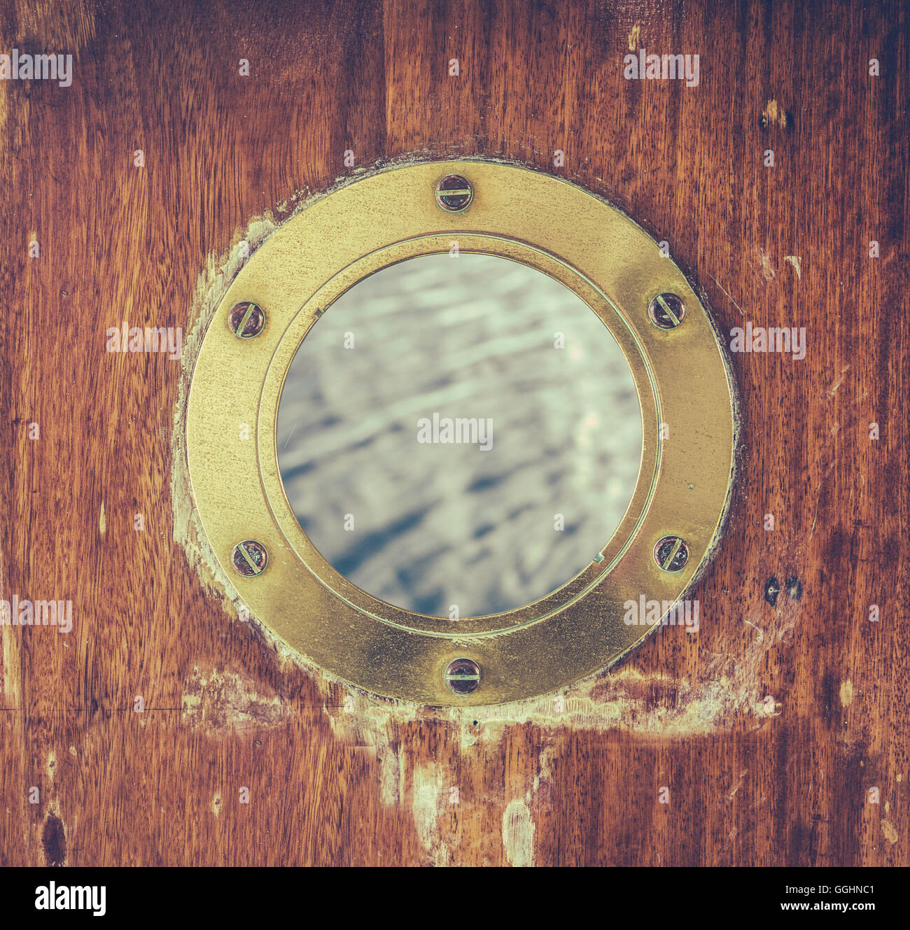 A Vintage Brass Porthole With Ocean Water Visible Stock Photo