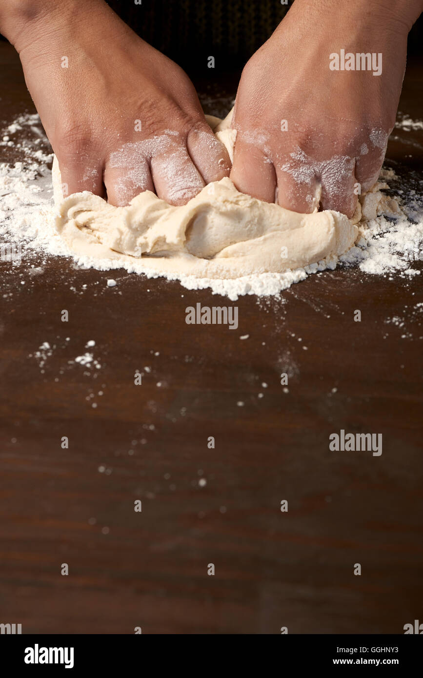 woman's hands kneading dough on wooden table Stock Photo - Alamy