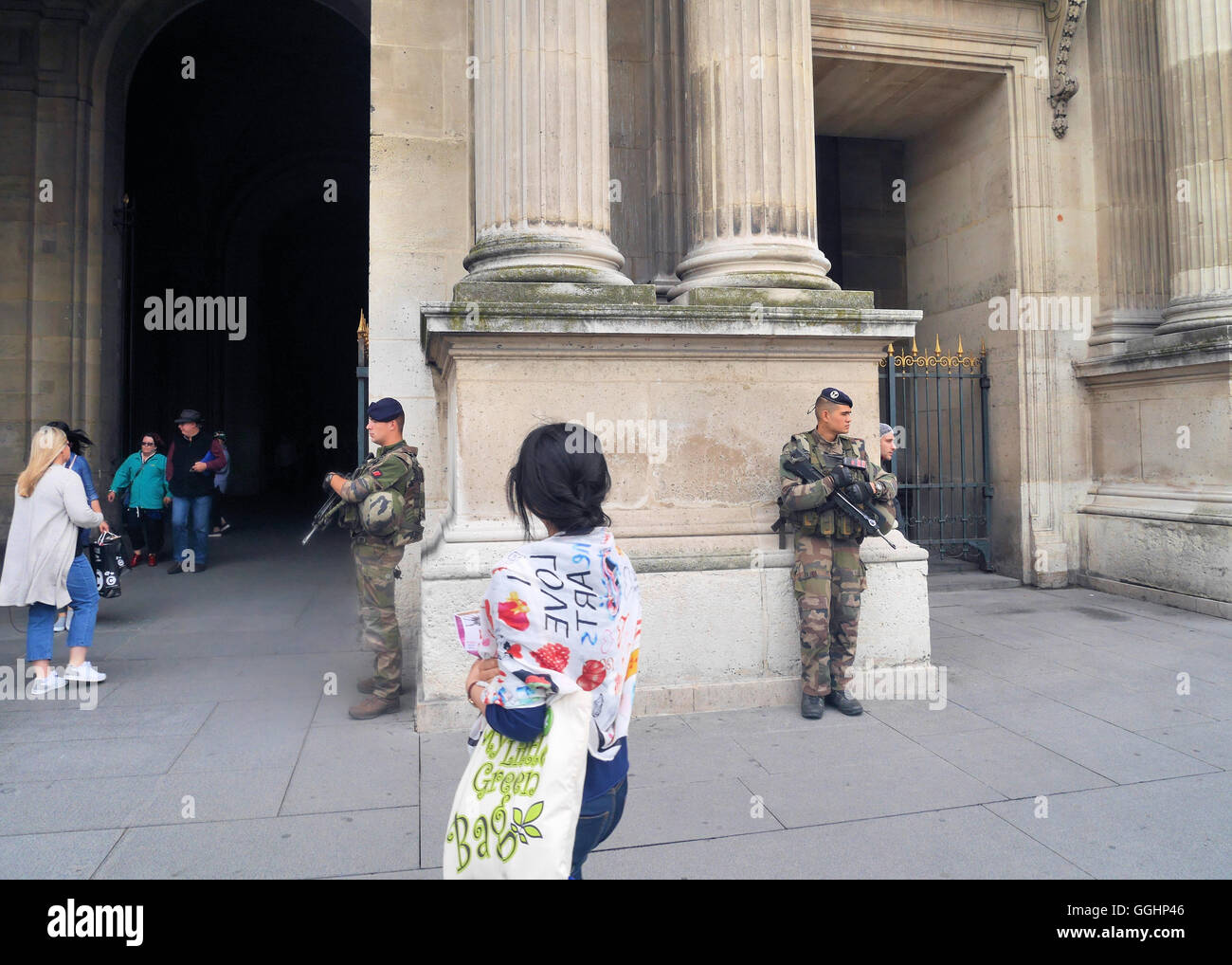 A woman looks on as French soldiers guard the area around the Louvre,Paris. Stock Photo