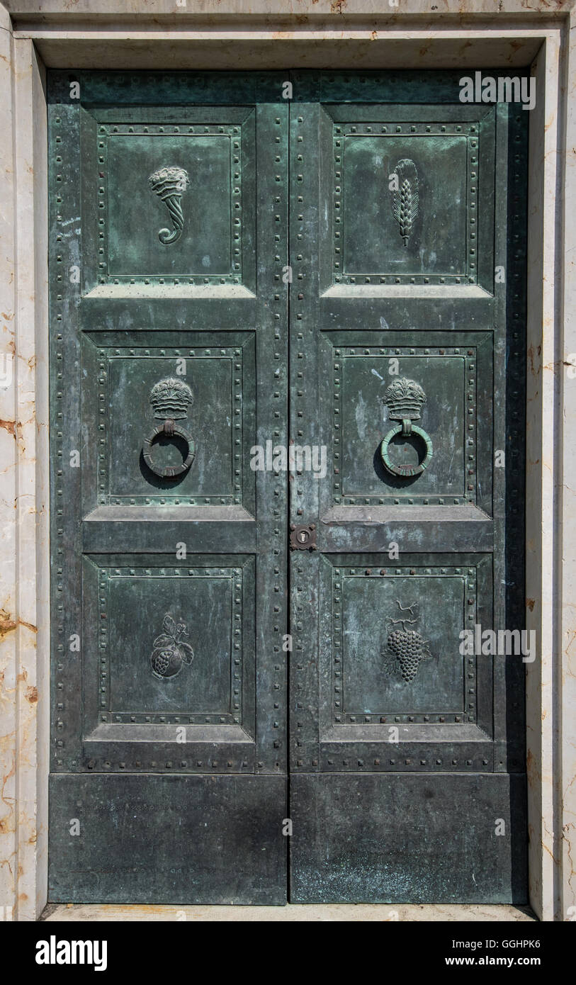 Ancient iron door with carved decorations and circular door knockers. Stock Photo