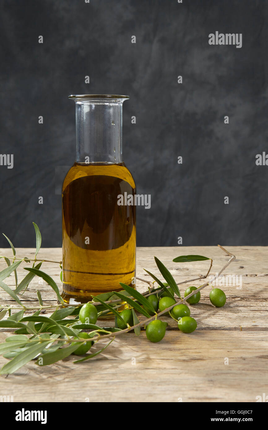 Olive branch and olive oil on the wooden table Stock Photo - Alamy