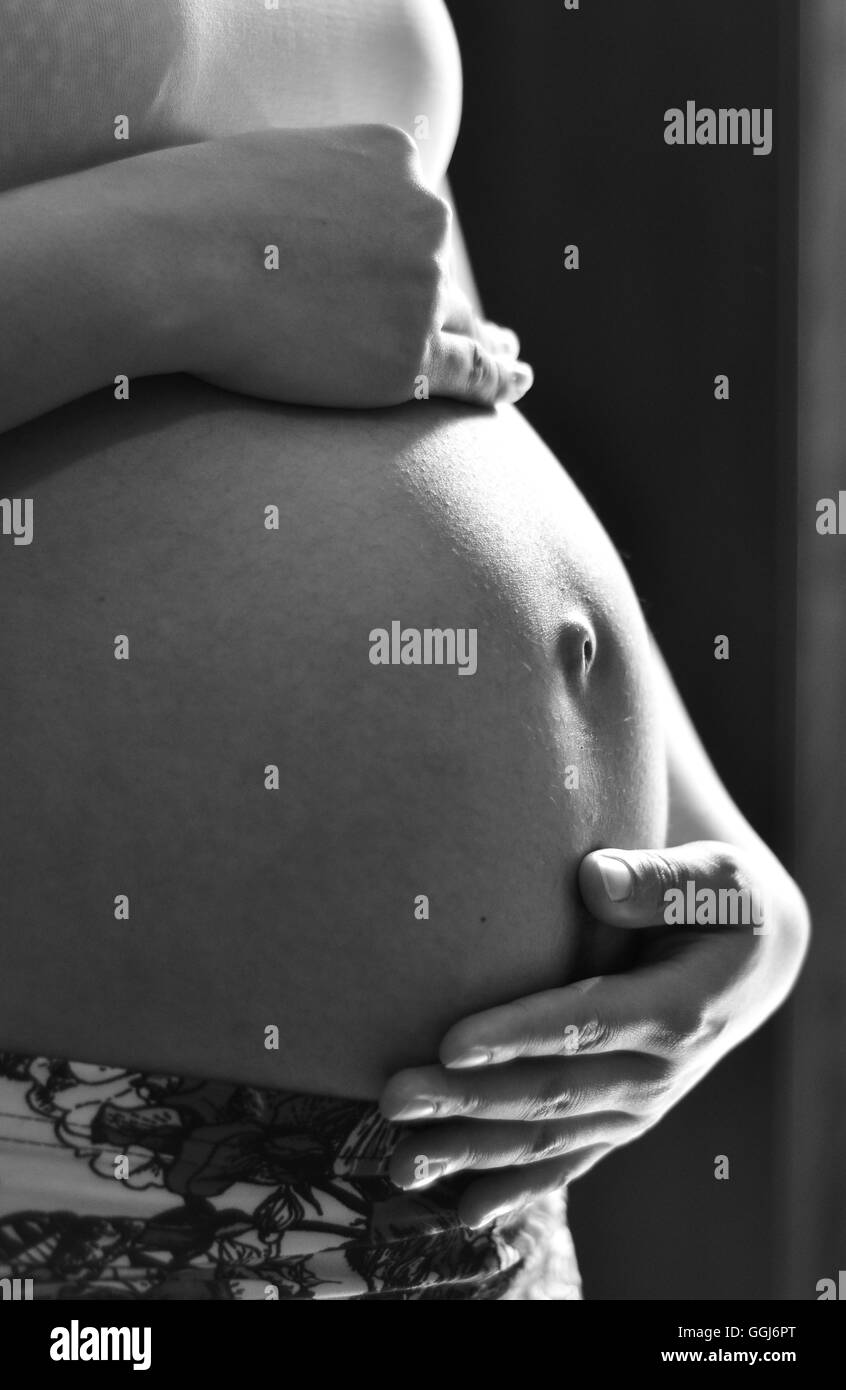 pregnancy pregnant expecting motherhood baby infant parenthood parent baby bump navel life miracle Stock Photo