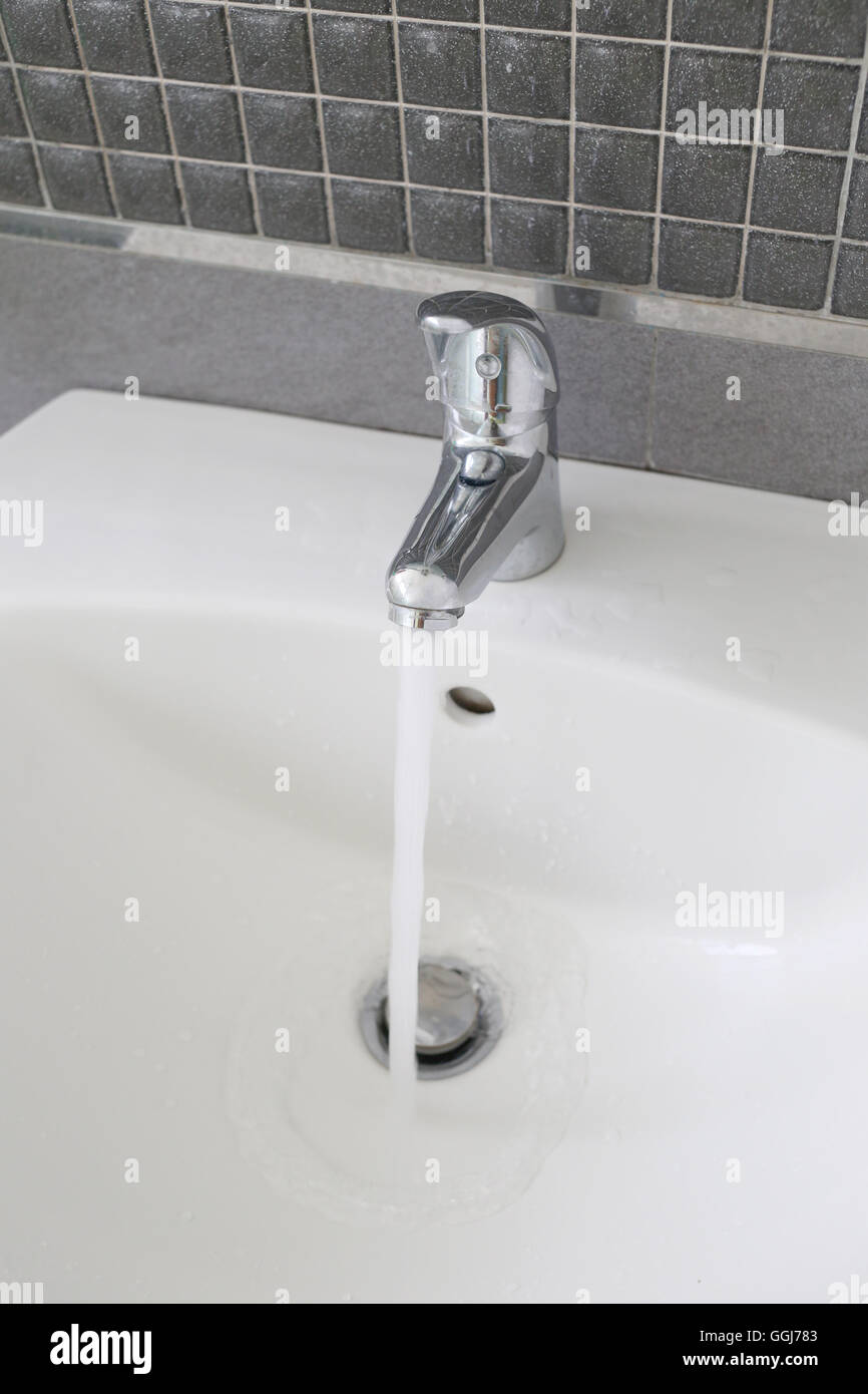 Bathroom silver faucet and have flowing water in concept of saving water. Stock Photo