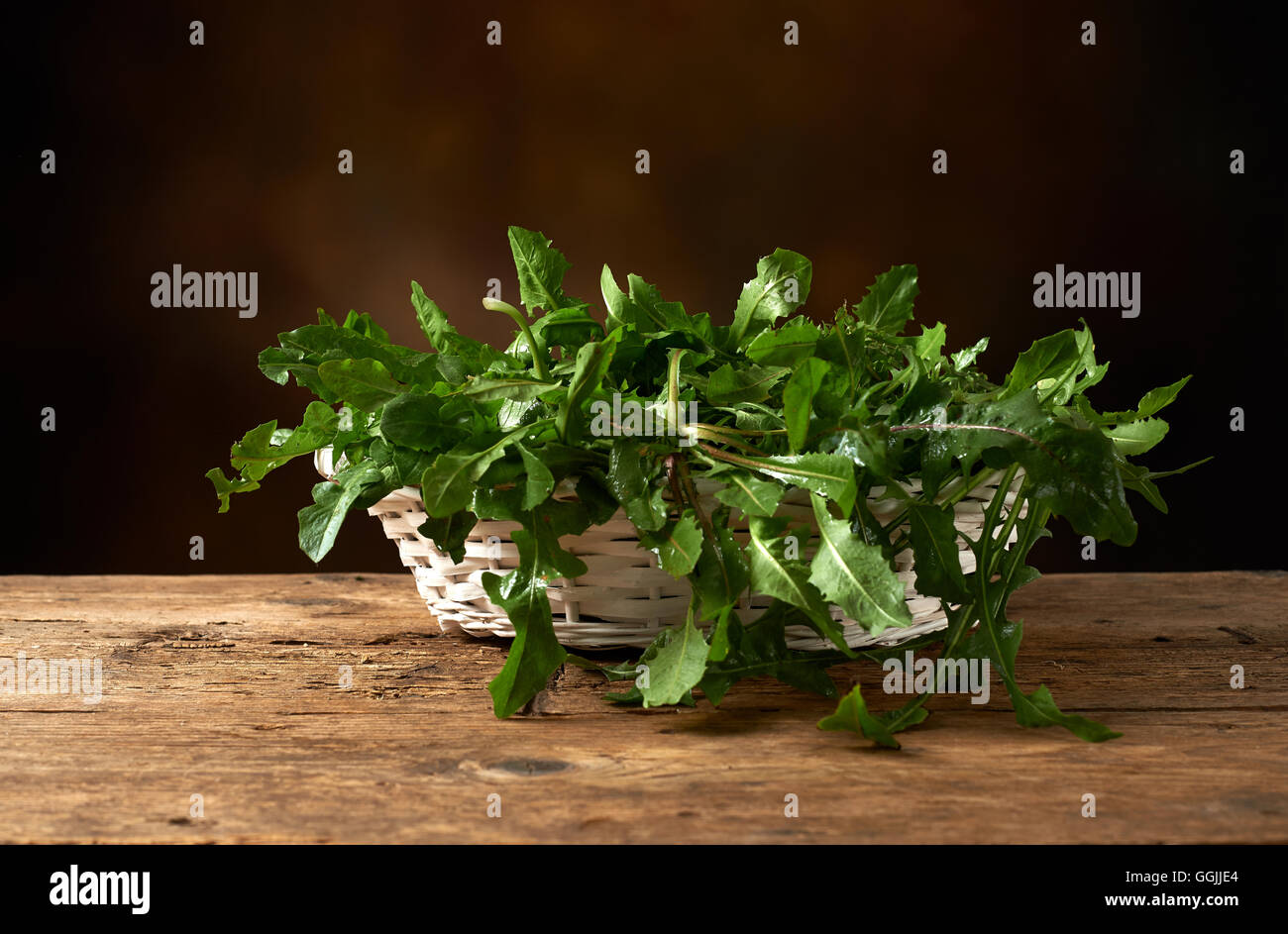 fresh green leafy vegetable on a wooden kitchen bench. Stock Photo