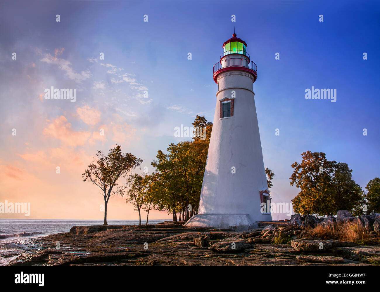 The Marblehead Lighthouse In The First Light Of Dawn On A Foggy Morning Over Lake Erie At Marblehead Ohio, USA Stock Photo